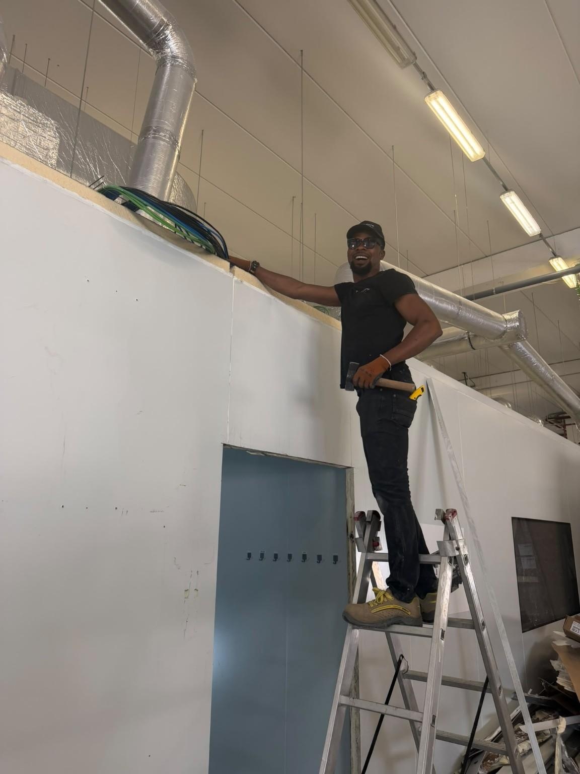 Operari instal·lant panells sandvitx en un recinte