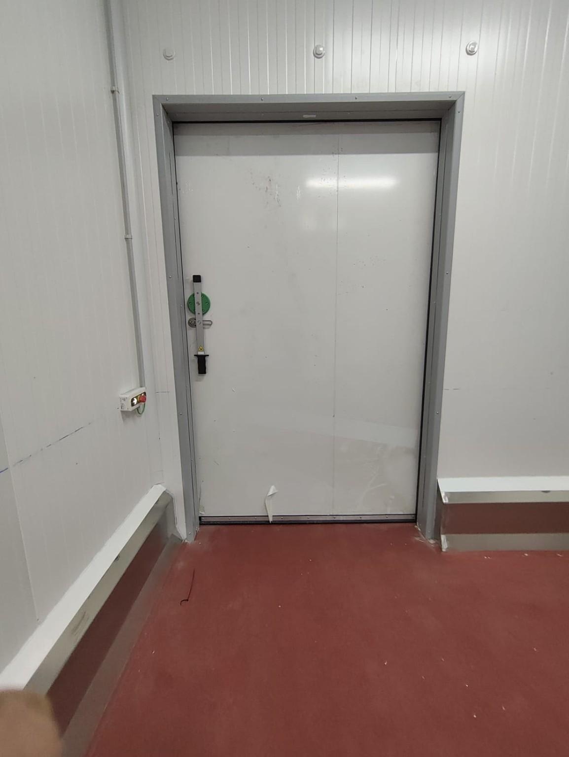 Porta corredissa sanitària de doble fulla instal·lada