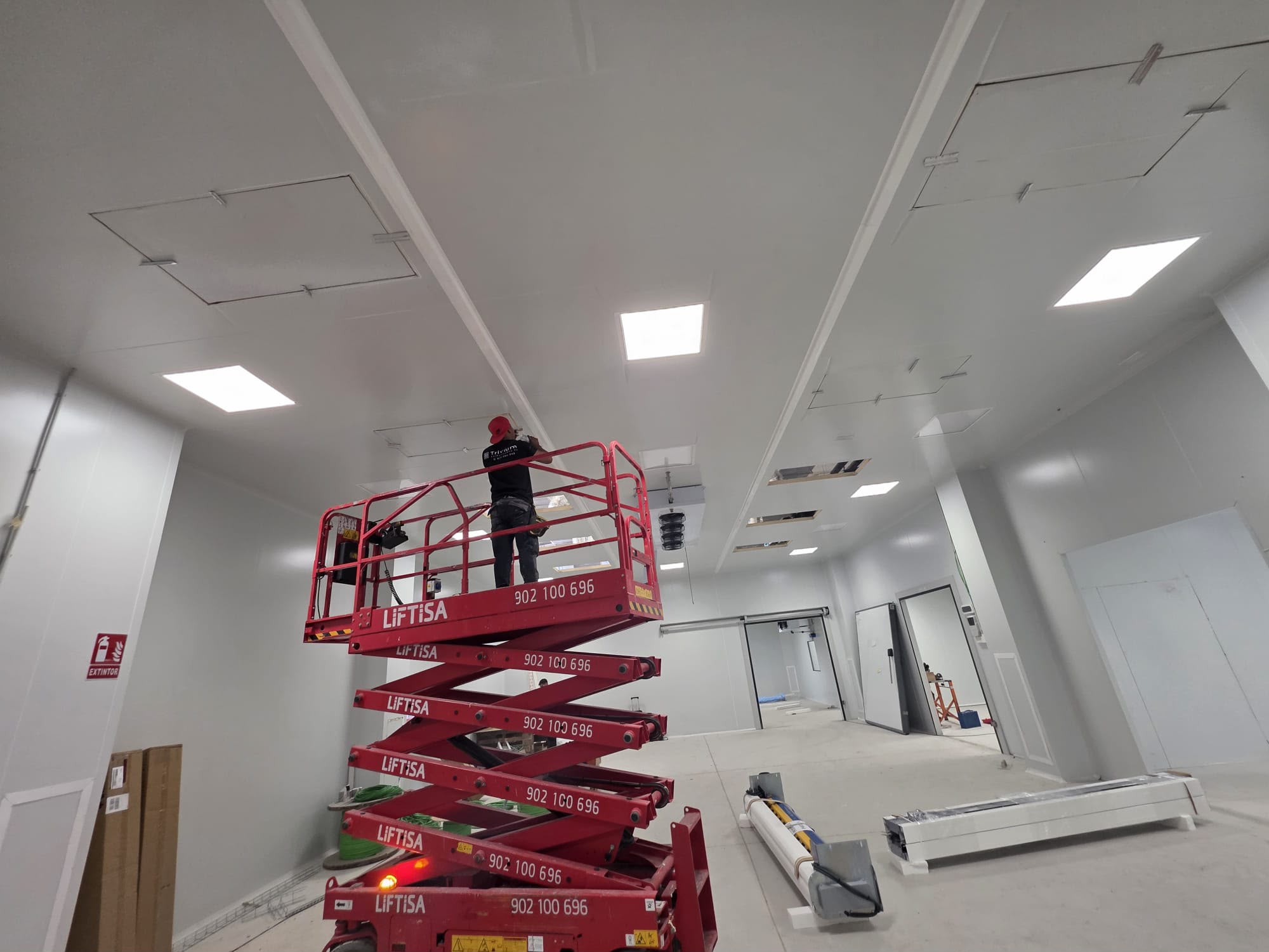 Operari muntant el sostre tècnic d'una sala blanca